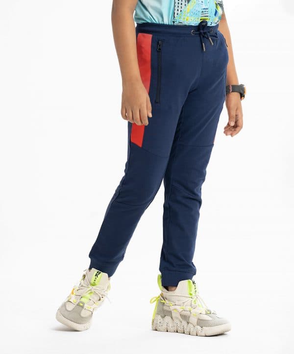 Kid boys slim fitted track pant in french terry fabric. Concealed elasticated waistline with drawstring cord. Two side pockets and a back pocket.