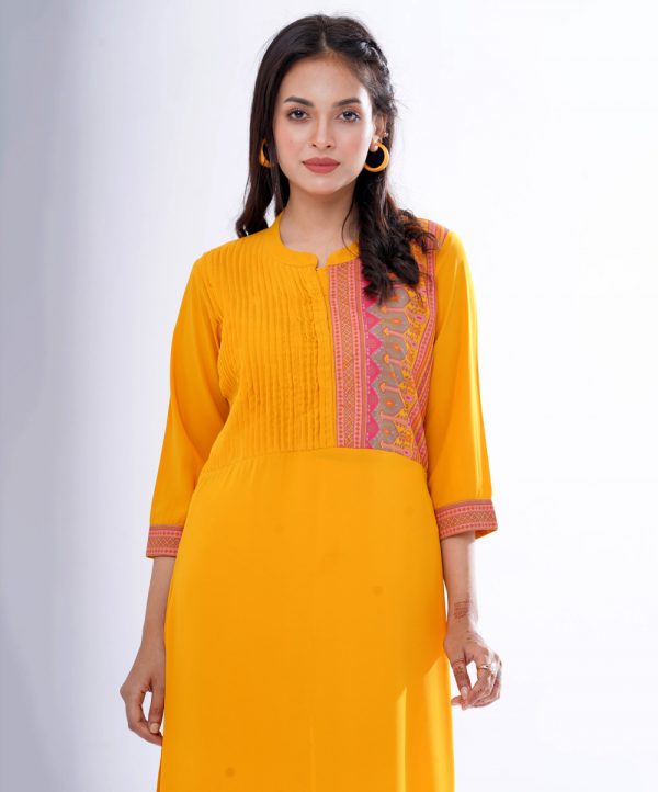 Yellow straight-cut kameez in Georgette fabric. Features a mandarin collar with hook closure at the front and three-quarter sleeves. Embellished with pin tucks at the front. Printed patch attachment at the cuffs and hemline. Unlined.