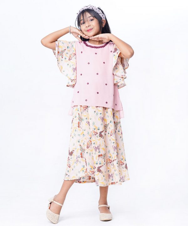 Pink Top-Skirt set in Georgette fabric. The top is designed with a round neck and butterfly sleeves. Embellished with embroidery at the front. Button opening at the back. Paired with a gathered skirt as the bottom.