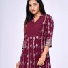 Burgundy all-over printed A-line Tunic in Viscose fabric. Features a lapel collar with hook closure at the front and three-quarter sleeves. Embellished with swing stitches and patch attachment at the top front. Pleats from the waistline.