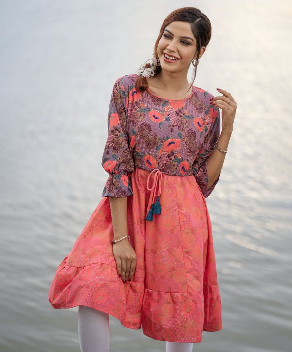 Pink all-over printed patterned A-line Tunic in Georgette fabric. Designed with a round neck and cinched cuff three-quarter sleeves. Embellished with karchupi at the top front. Featuring adjustable tasseled waist cords at the front and spliced gather hemline. Viscose lining in half-body. Single button opening at the back.
