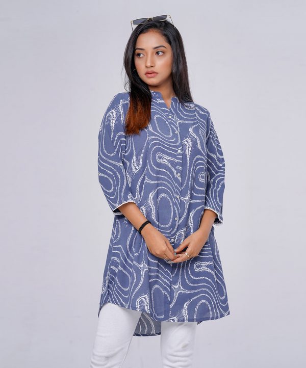 Blue ladies shirt in printed Georgette fabric. Designed with a classic shirt collar, front button opening and three-quarter sleeves. Detailed with a princess line cut at the front and front pockets.
