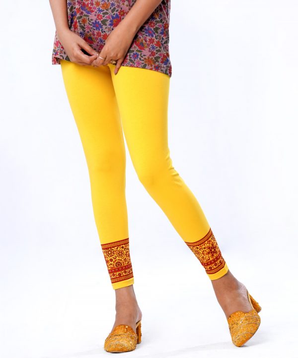 Yellow legging in stretchable cotton knit fabric with prints on the border. Concealed elastication on the waistline.