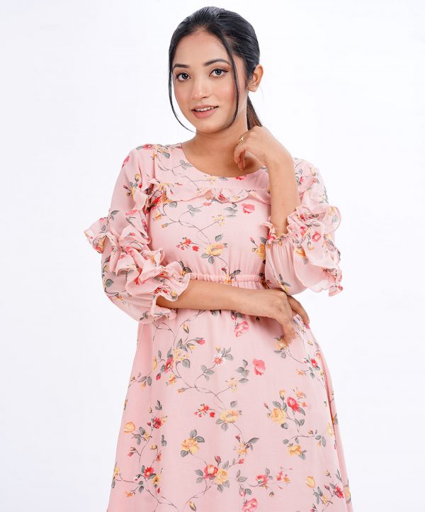Peach A-line Tunic in printed Georgette fabric. Designed with a round neck and cinched bishop sleeves. Detailed with extended ruffle till sleeves cuffs at both sides. Single button opening at the back.