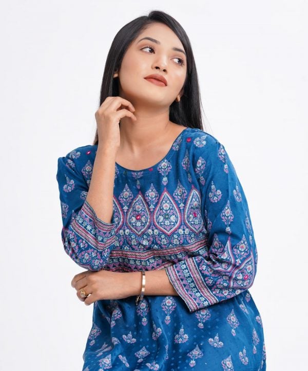 Blue all-over printed A-line Tunic in textured Silk-blend fabric. Designed with a round neck and three-quarter sleeves. Embellished with karchupi at the top front and cuffs. Viscose lining in half-body. Single button opening at the back.