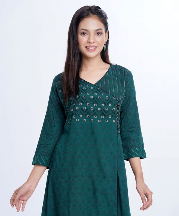 Green all-over printed Retro-wrap style Tunic in Viscose fabric. Designed with a V-neck, three-quarter sleeves. Embellished with embroidery, fancy button and pin tucks at the top front.