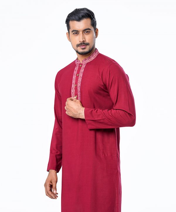 Red semi-fitted Panjabi in Slab Viscose fabric. Embellished with minimal karchupi on the collar and placket. Metal button opening on the chest.