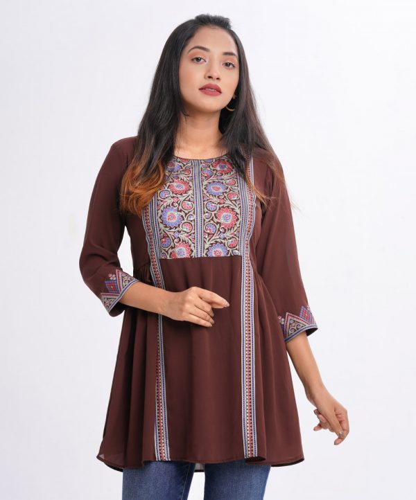 Chocolate A-line Tunic in Georgette fabric. Designed with a round neck and three-quarter sleeves. Embellished with patch attachment at the front and gathers from the waistline.