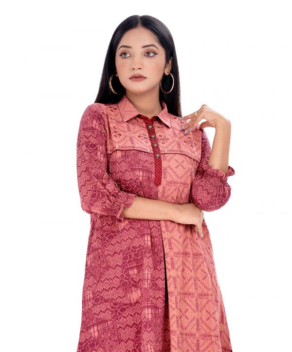 Salmon Pink A-line Tunic in Georgette fabric. Designed with a shirt collar and bishop sleeves. Embellished with embroidery at the top front.