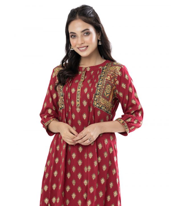 Maroon all-over printed ladies’ Shirt in Viscose fabric. Features a band neck with hook closure at the front and three-quarter sleeves with buttoned cuffs. Designed with pin tucks at the front. High-low hemline.