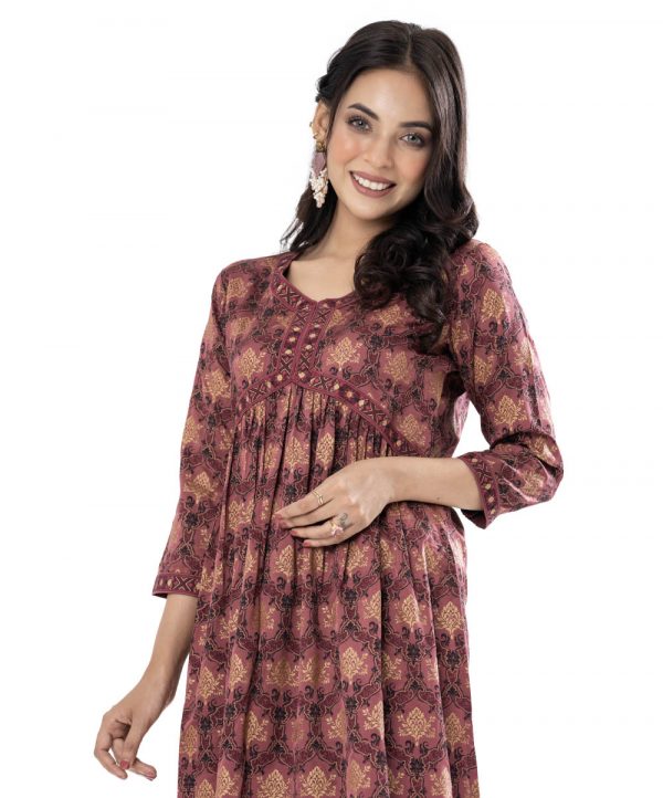 Copper rose all-over printed A-line Tunic in Crepe fabric. Designed V-neck and three-quarter sleeves. Embellished with printed patch attachment at the front, cuffs and hemline. Gathered at the front.