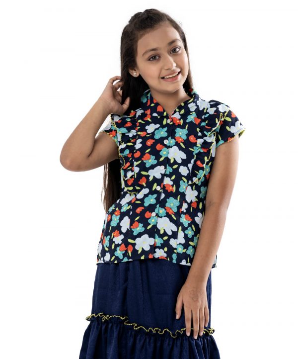 Navy Blue Top-Skirt set in printed Georgette fabric. The top features a band neck with buttons opening at the front and cap sleeves. Extended ruffles at the front. Paired with a gathered skirt as the bottom.