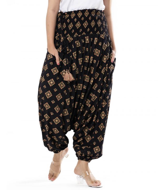 Black all-over printed Harem pants in Viscose fabric. Designed with smoked waistline with adjustable tasseled waist cords and side packets.