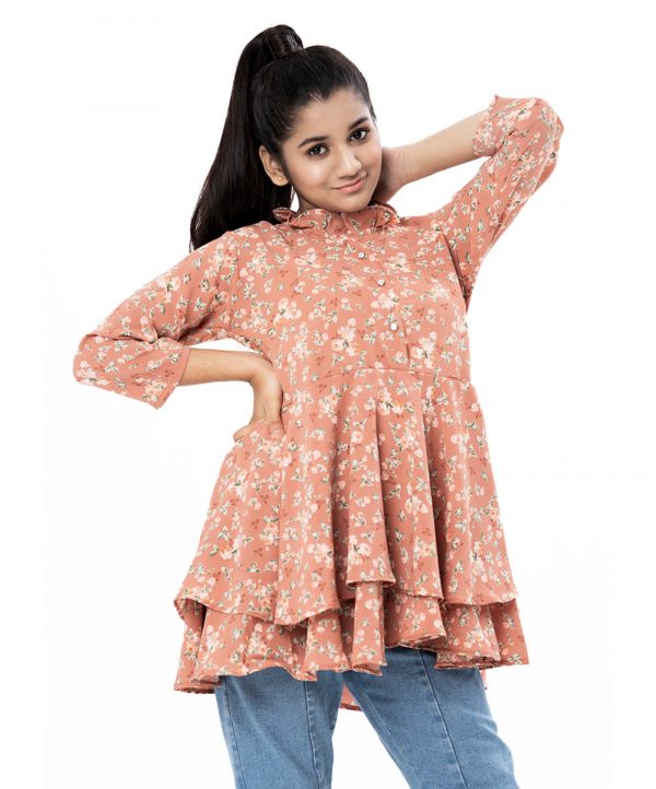 Peach layered A-line Tunic in printed Georgette fabric. Features a round neck with frills and three-quarter sleeves. Gathers from the waistline.