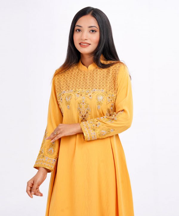 Yellow A-line Tunic in jacquard Georgette fabric. Designed with a high neck and full sleeves. Embellished with embroidery at the top front and cuffs. Elongated hemline. Button opening at the back.