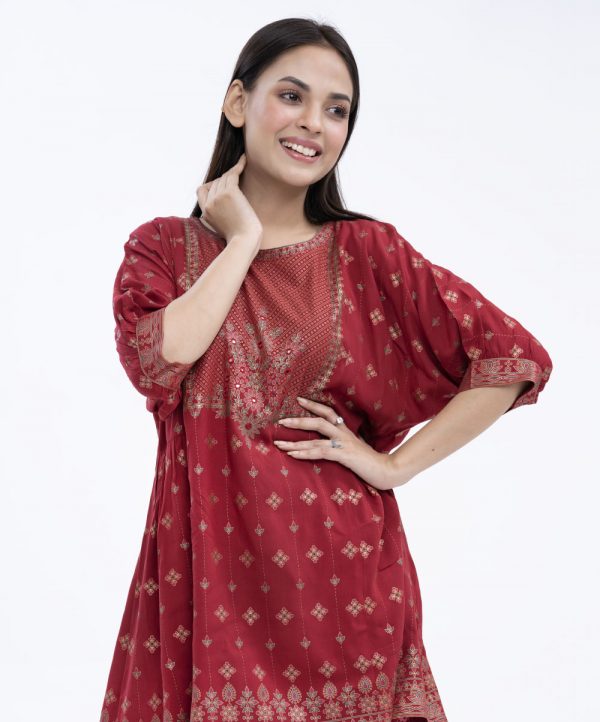 Red all-over printed A-line Tunic in Viscose fabric. Designed with a round neck and dropped sleeves. Embellished with karchupi at the top front. Gathers from the waistline. Single button opening at the back.
