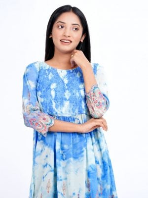 Sky blue tunic in printed Georgette fabric. Designed with a round neck and three-quarter sleeves. Smoked detailing at the top front. Gathers from the waistline.