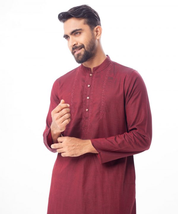 Maroon premium Panjabi in Cotton fabric. Designed with a mandarin collar and matching metal buttons on the placket. Embellished with karchupi at the top front.