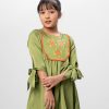 Green A-line Tunic in Crepe fabric. Designed with a round neck and elbow-length knot sleeves. Embellished with karchupi and lace at the top front. Minimal gathers at the front. Button opening at the back. Unlined.