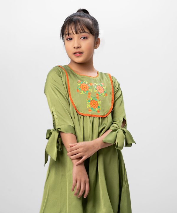 Green A-line Tunic in Crepe fabric. Designed with a round neck and elbow-length knot sleeves. Embellished with karchupi and lace at the top front. Minimal gathers at the front. Button opening at the back. Unlined.