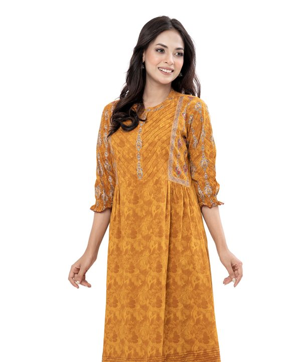 Mustard Yellow all-over printed A-line Tunic in Viscose fabric. Features a band neck with hook closure at the front and cinched bishop sleeves. Embellished with embroidery and pin tucks at the top front. Gathers from the waistline. Swing stitches and patch attachment at the hemline.