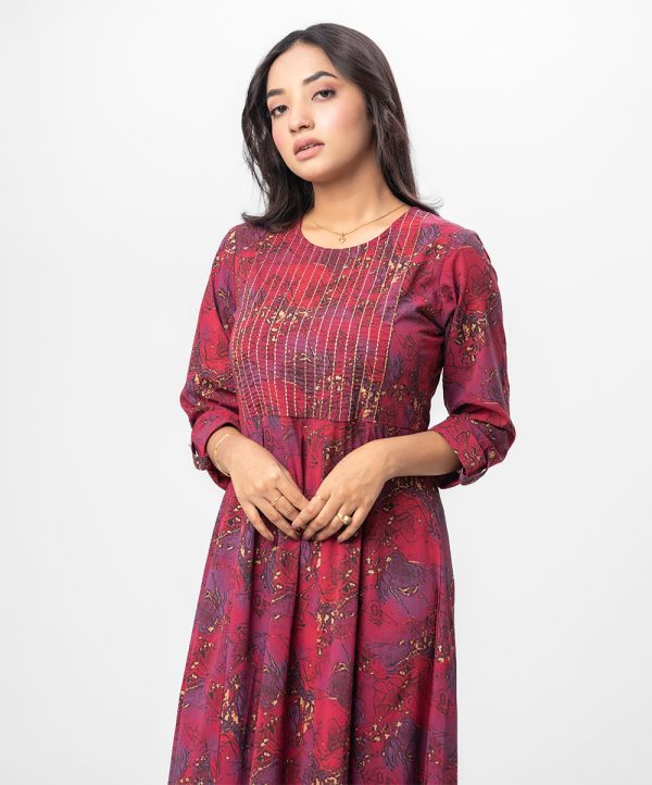 Maroon all-over printed patterned Gown in Georgette fabric. Designed with a round neck and three-quarter sleeves. Embellished with swing stitch at the top front. Single button opening at the back. Unlined.