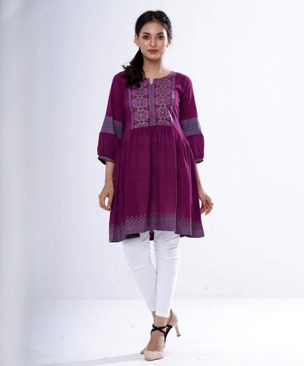 Purple Tunic in printed Georgette fabric. Designed with a round neck and lantern sleeves. Embellished with patch attachment at the top front and gathers from the waistline. Unlined.