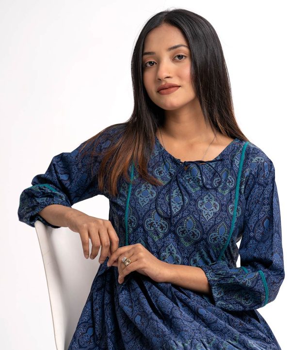 Navy blue all-over printed A-line Tunic in Viscose fabric. Designed with a round neck with tasselled tie-cord and bishop sleeves. Embellished with lace attachment at the front and cuffs. Gathers from the waistline.
