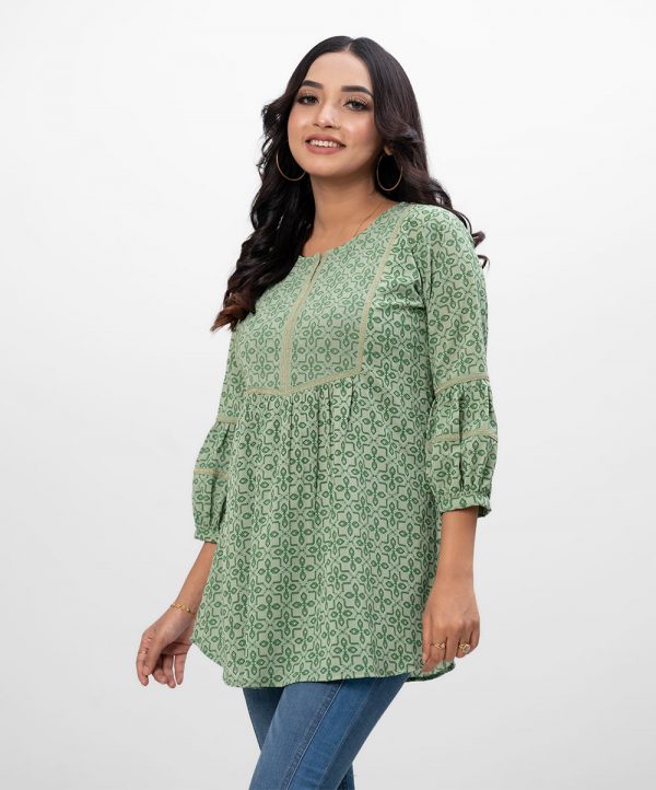 Green A-line Tunic in printed Georgette fabric. Features a round neck with hook closure at the front and lantern sleeves. Embellished with embroidery at the front. Unlined.