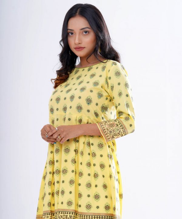 Yellow all-over printed A-line Maternity Tunic in Viscose fabric. Designed with a round neck and three-quarter sleeves. Embellished with embroidery at the top front and box pleats from the waistline.