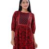 Maroon and Black Tunic in Printed Georgette fabric. Designed with a low mock neck and bishop sleeves. Embellished with embroidery at the top front and gathers from the waistline. Single button opening at the back. Unlined.