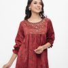 Maroon all-over printed woven top in Crepe fabric. Designed with a round neck and bishop sleeves. Embellished with karchupi and pleats at the front. Single button opening at the back. Unlined.
