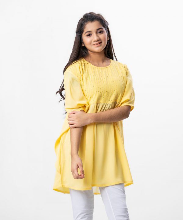 Yellow kaftan style Tunic in Georgette fabric. Designed with a round neck and bat sleeves. Embellished with karchupi at the top front and gathers from the waistline. Single button opening at the back. Viscose lining in half-body.