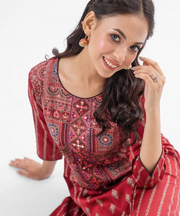 Maroon all-over printed A-line Kameez in Crepe fabric. Designed with a round neck and three-quarter sleeves. Embellished with karchupi at the top front. Single button opening at the back. Unlined.