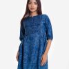 Woman's floral printed A-line tunic in denim fabric. Three-quarter sleeved, band collar. Gather waistline with inseam side pockets.