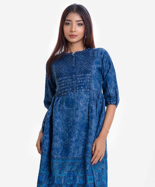 Woman's floral printed A-line tunic in denim fabric. Three-quarter sleeved, band collar. Gather waistline with inseam side pockets.