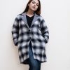 Women's single-breasted check long pattern trench coat in houndstooth fabric. Lapel collar, full sleeves. Two side pockets.
