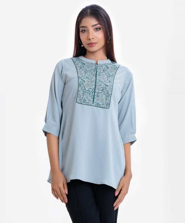 Women's A-line tunic in design georgette fabric. Band collar, three-quarter sleeves. Floral print and embroidery at the front.