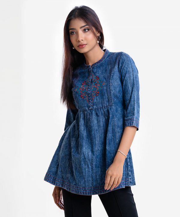 Women's A-line tunic in denim fabric. Band collar, three-quarter sleeves. Embroidery at front.