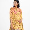 Ladies A-Line Shirt in printed georgette fabric. Stand collar, roll-up sleeved. Button fasting and attached lace and tassel tie at the front.