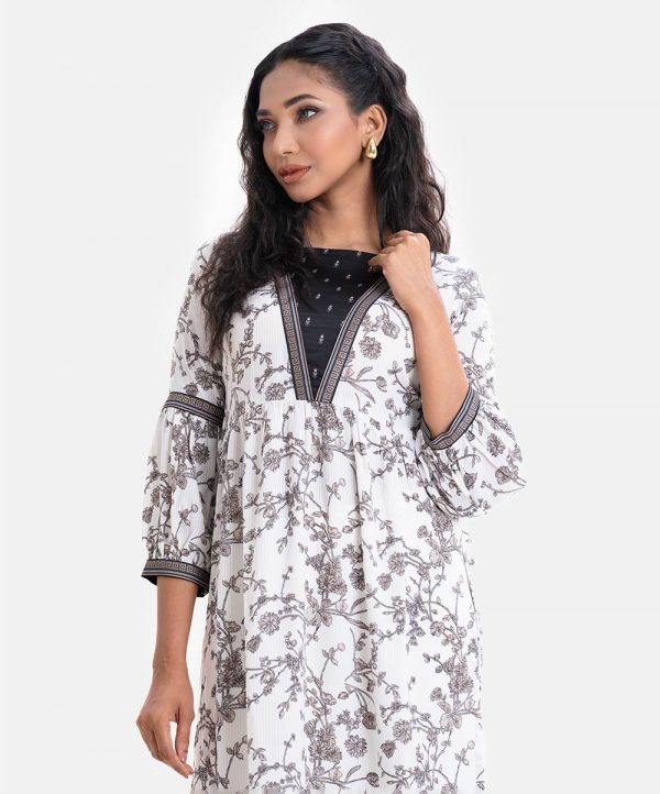 Women's floral printed high-low hem style kameez in printed georgette fabric. Contrast patch on collar, three-quarter sleeves and bottom hemline. Gathered waistline with side open.