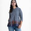 Ladie's printed shirt in chambray fabric. Band collar, long-sleeved. Button fasting and pattern work at the front.