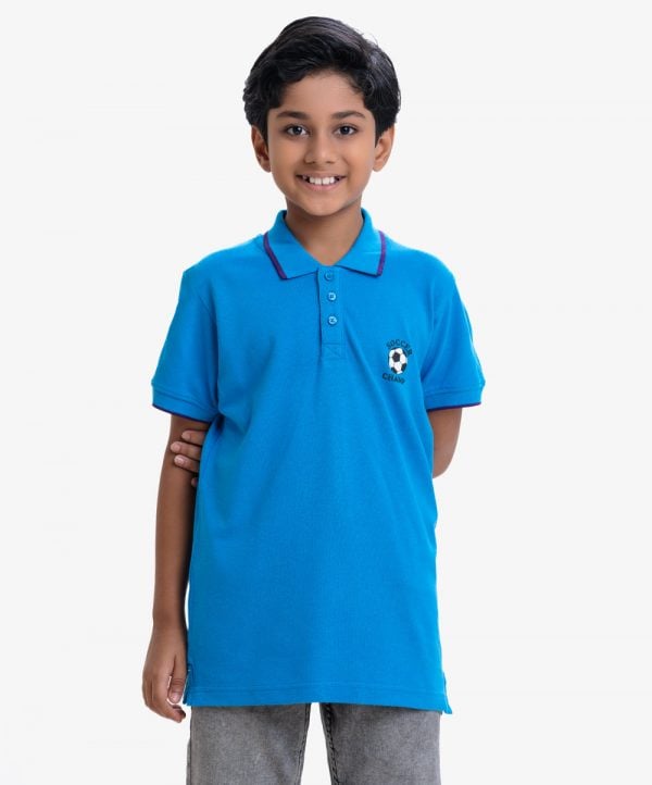 Kid boys short-sleeved polo shirt in cotton pique fabric. Soccer ball print print at front. Twill tape attaches to the collar and sleeves.
