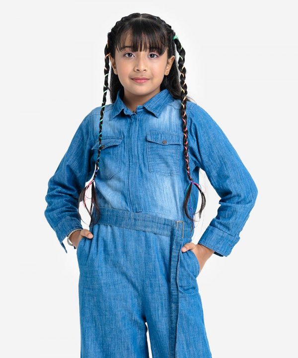 KIds girls jumpsuit in chambray fabric. Classic collar, long-sleeved. front opening zipper and two pockets at the front.