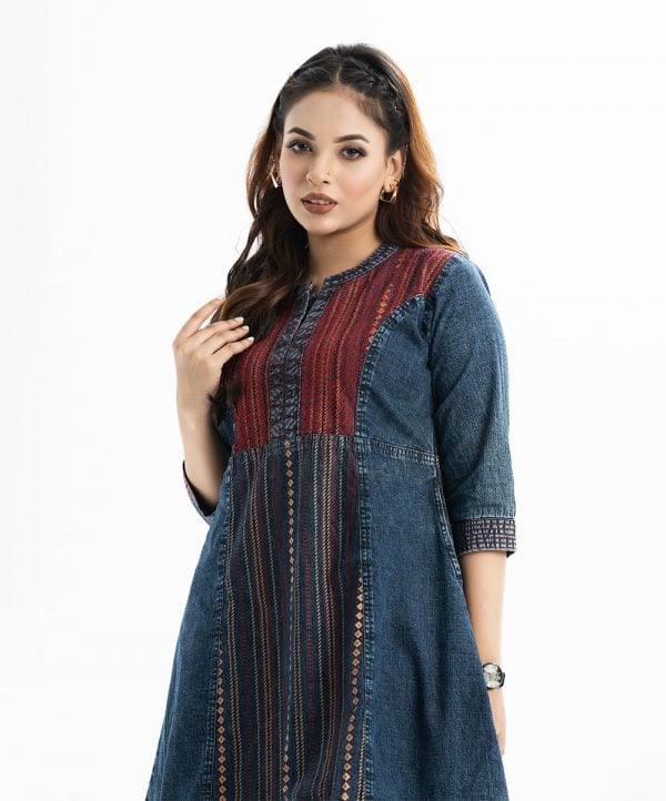 Woman's A-line tunic in denim fabric. Three-quarter sleeves, stand collar with placket. Embroidery at front.