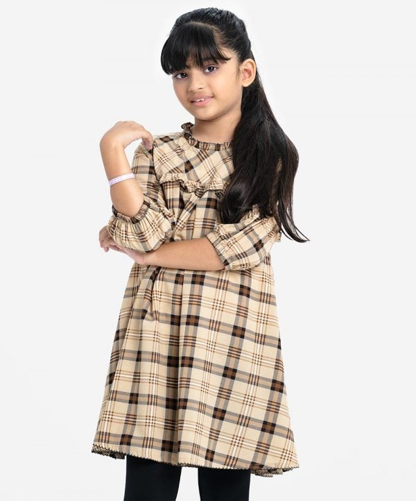 Kids girl A-line tunic in check fabric. Ruffle neck, puff-sleeved, and frill trims at the front.