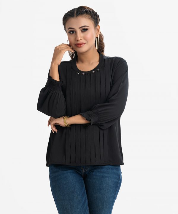 Women's top in georgette fabric. Mock neck, long puff sleeved. Stone and pin-tuck at the front.
