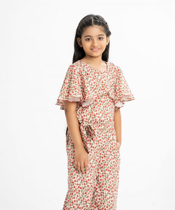 KId's girl jumpsuit in printed georgette fabric. Round neck, circular sleeved. Two side pockets with waistbelt and wrap layer at the front.
