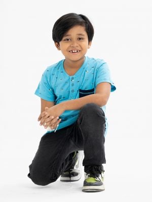 Kid boys henley T-shirt in cotton single jersey fabric. Rounded scoop neckline with front button fastening and short sleeves. All-over playfull prints with a chest pocket.