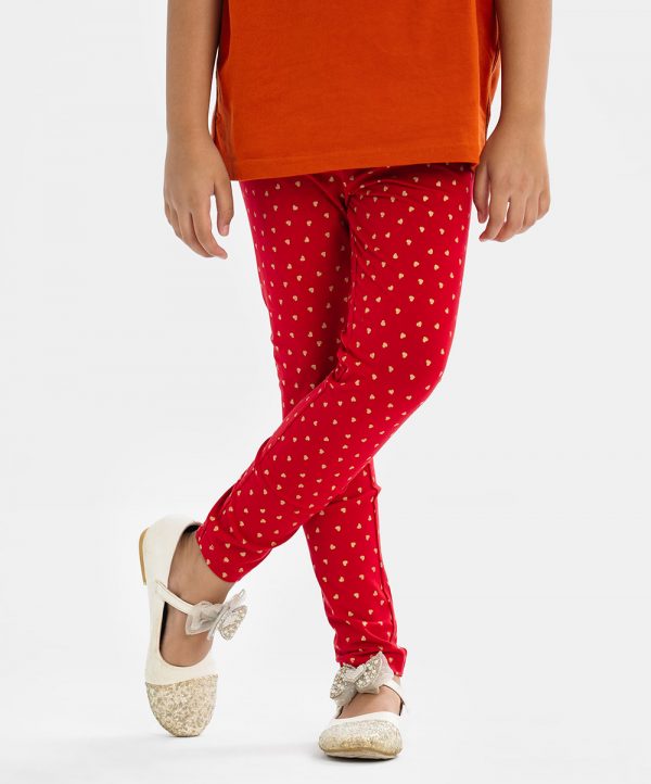 Kid girl's leggings in stretchable cotton knit fabric. Concealed elasticated waistline and all over heart printed.